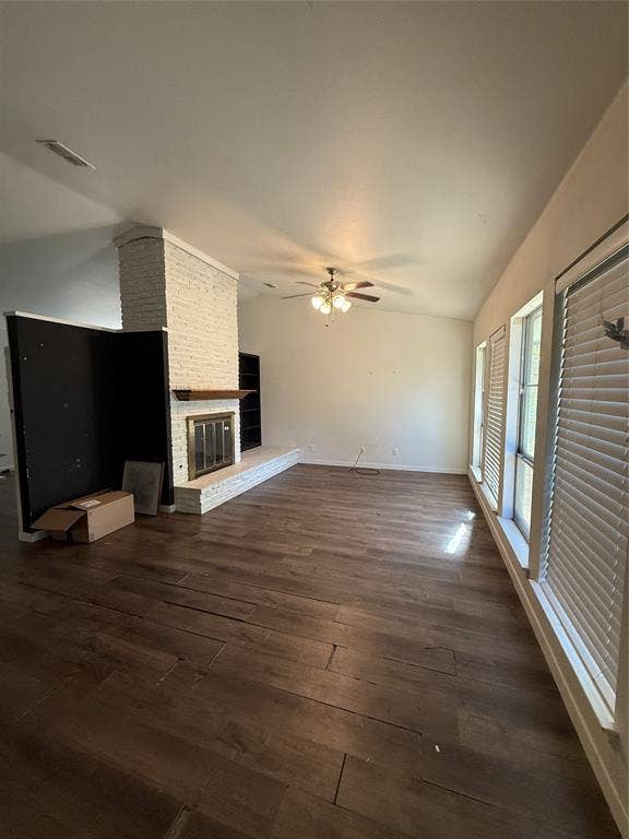 3825 Eugene Court N, Irving, TX 75062 Living area featuring wood-finish flooring, vaulted ceilings, a whitewashed brick fireplace with a wood mantel, built-in shelving, and large windows with horizontal blinds