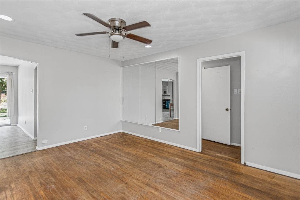1220 Colfax Circle, Richardson, TX 75080 Room featuring wood-finish flooring, recessed lighting, a brushed-metal ceiling fan, and wall-to-wall mirrored closet doors