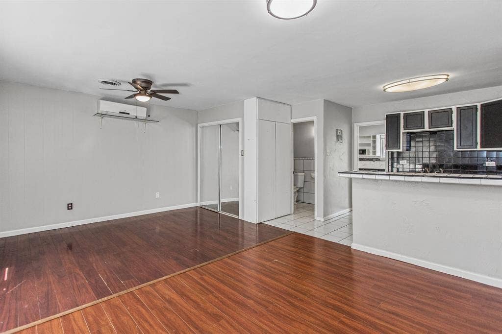 1220 Colfax Circle, Richardson, TX 75080 Wood-finish flooring, wall-mounted ductless air conditioning unit, ceiling fan, mirrored closet doors, and tile-topped breakfast bar