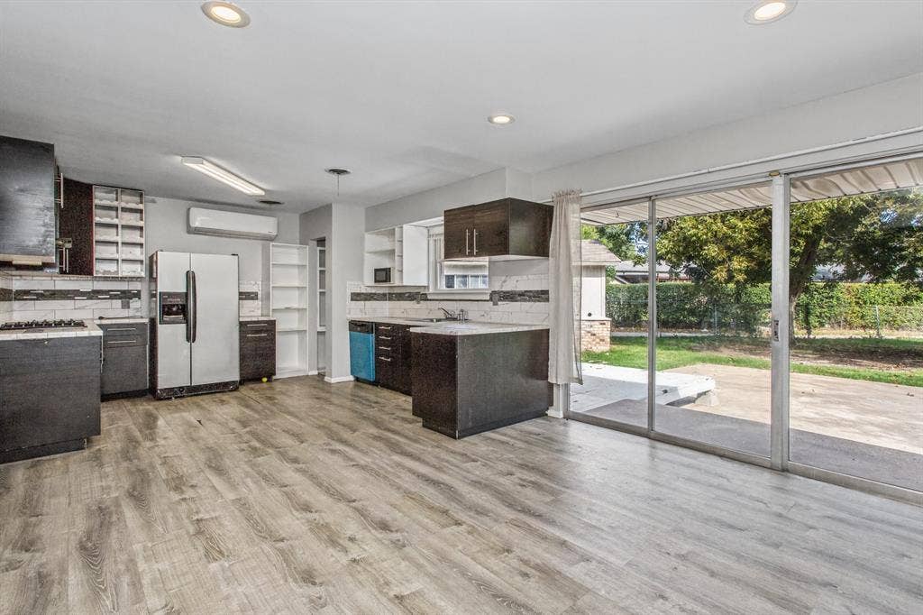 1220 Colfax Circle, Richardson, TX 75080 Kitchen featuring dark cabinetry, stone-finish countertops, wood-finish flooring, recessed lighting, and sliding glass doors to the exterior