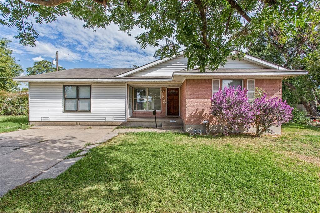 1220 Colfax Circle, Richardson, TX 75080 Single-story residence featuring a mixed brick and horizontal siding exterior, concrete driveway, and front porch
