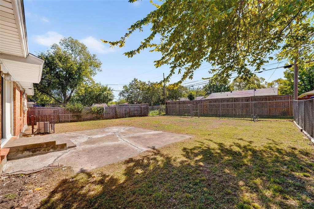 3532 Hilton Drive, Mesquite, TX 75150 Rear yard featuring a concrete patio, open lawn area, and perimeter wood fencing