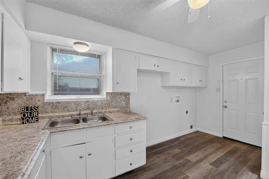 3532 Hilton Drive, Mesquite, TX 75150 Kitchen featuring white cabinetry, stone-finish countertops, a double-basin stainless steel sink, wood-finish flooring, and a ceiling-mounted light fixture