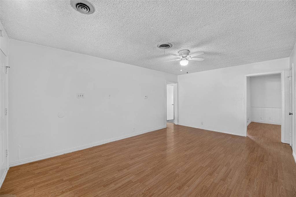 3532 Hilton Drive, Mesquite, TX 75150 Interior space featuring wood-finish flooring, white walls, and a ceiling-mounted light fixture with fan