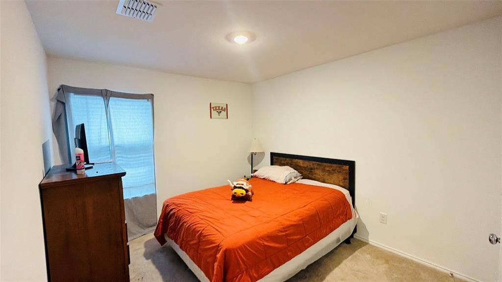 Neutral-toned walls, carpeted flooring, and a flush-mount ceiling light fixture