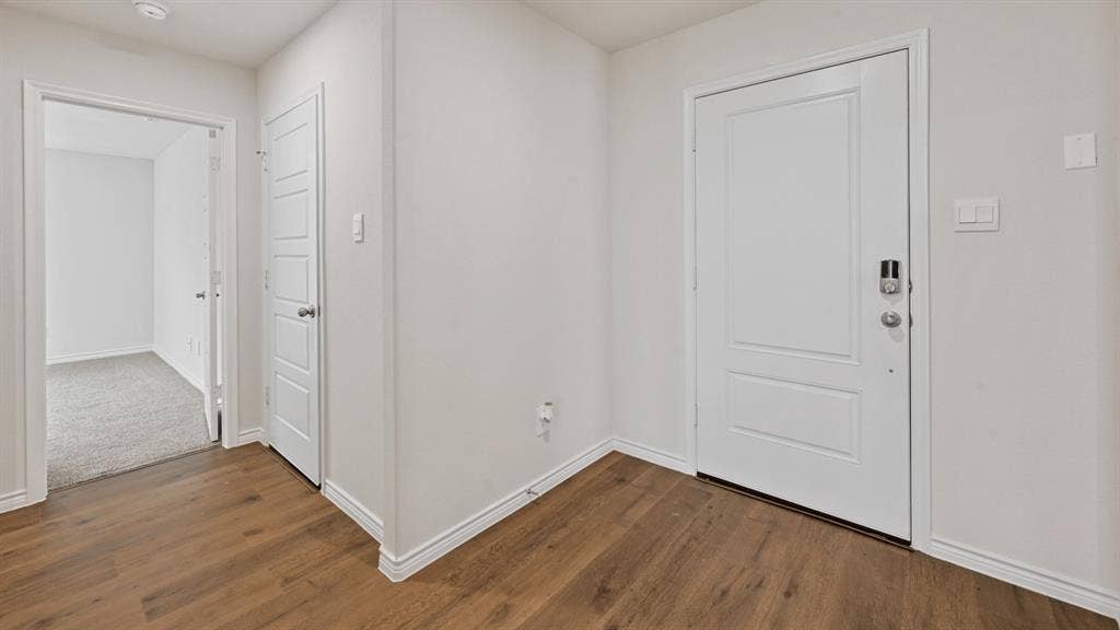 Wood-finish flooring, white paneled doors, recessed lighting, and light gray wall paint