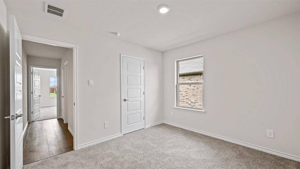 Carpeted room with a single window, white walls, and recessed lighting