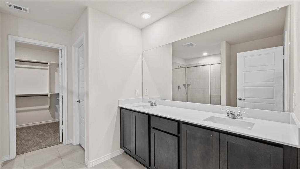 Dual sink vanity with dark wood-finish cabinetry and white countertops