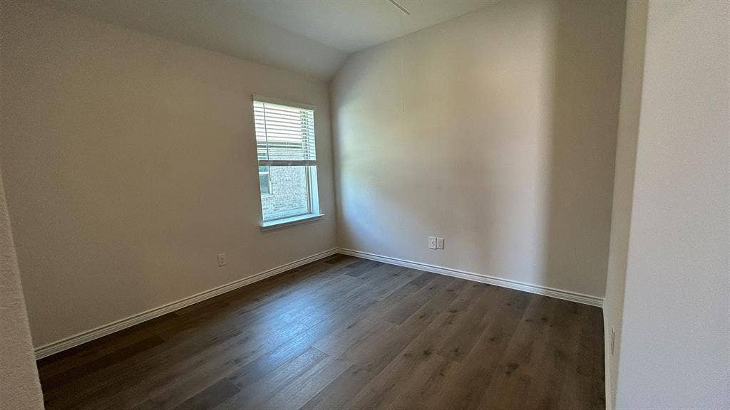 410 Campfield Drive, Caddo Mills, TX 75135 Room featuring vaulted ceilings, wood-finish flooring, and natural light from a single window