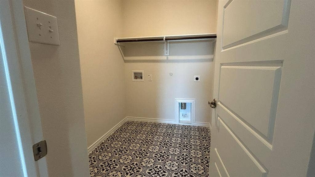 410 Campfield Drive, Caddo Mills, TX 75135 Utility area featuring patterned ceramic tile flooring, a wall-mounted shelving unit, and recessed plumbing hookups