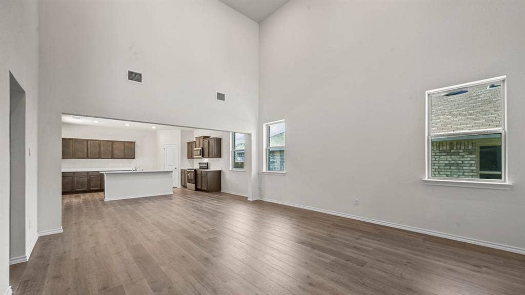 5727 Sunshine Lane, Crandall, TX 75114 Vaulted ceilings, wood-finish flooring, two windows, recessed lighting, and a kitchen featuring dark wood cabinetry and white countertops