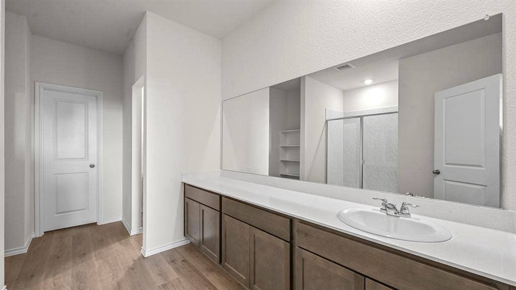 5727 Sunshine Lane, Crandall, TX 75114 Spa-inspired primary bathroom featuring an extended vanity with wood-finish cabinetry, white quartz countertop, and chrome fixtures