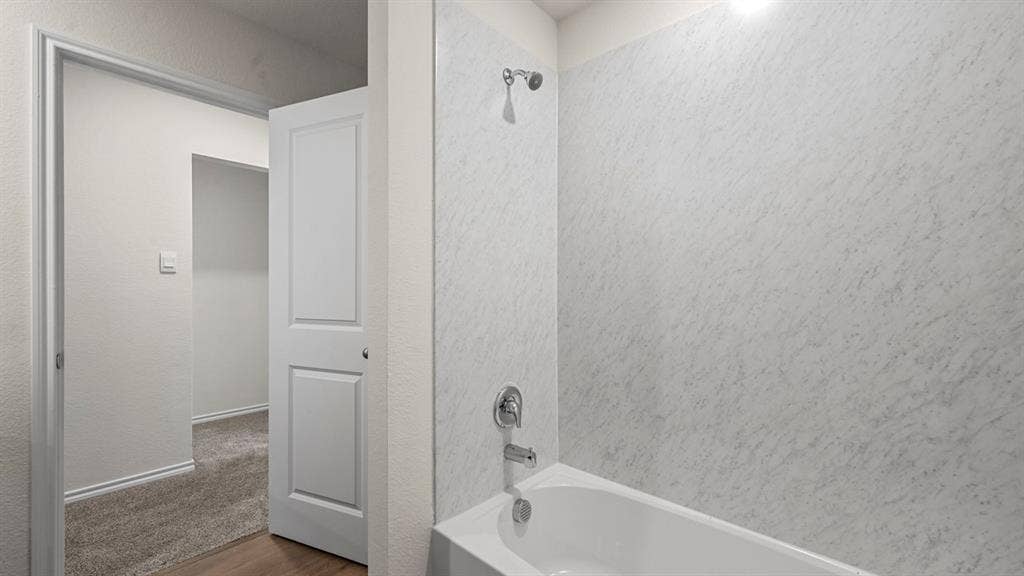 5727 Sunshine Lane, Crandall, TX 75114 Tub and shower combination with chrome fixtures and light-toned surround