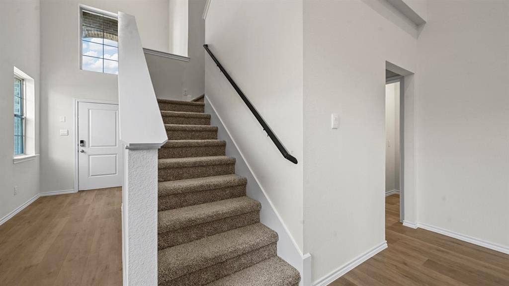 5727 Sunshine Lane, Crandall, TX 75114 Two-story entryway with wood-finish flooring, a carpeted staircase, and high ceilings