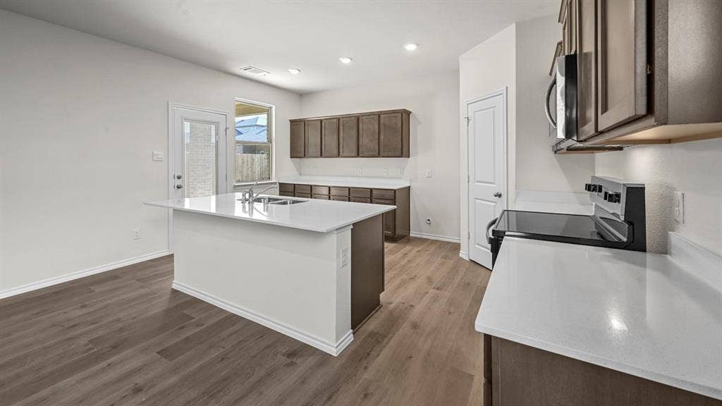 5727 Sunshine Lane, Crandall, TX 75114 Kitchen featuring a central island, wood-finish flooring, recessed lighting, white countertops, and stainless steel appliances