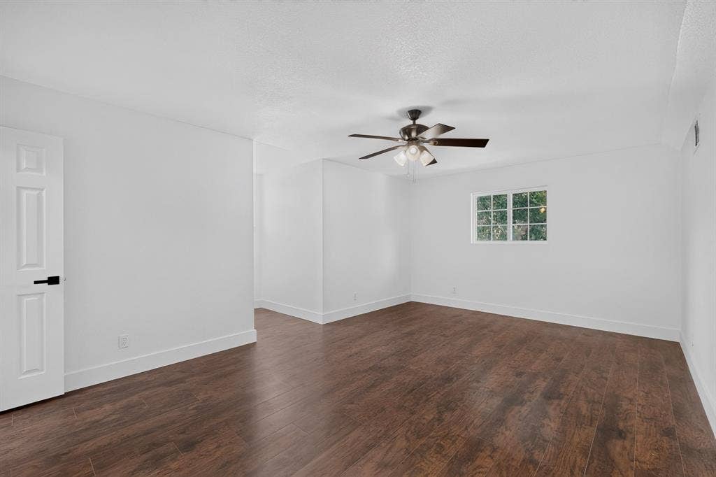 550 Glen Oaks Boulevard, Dallas, TX 75232 Interior space featuring wood-finish flooring, a multi-pane window, and a ceiling fan with integrated lighting