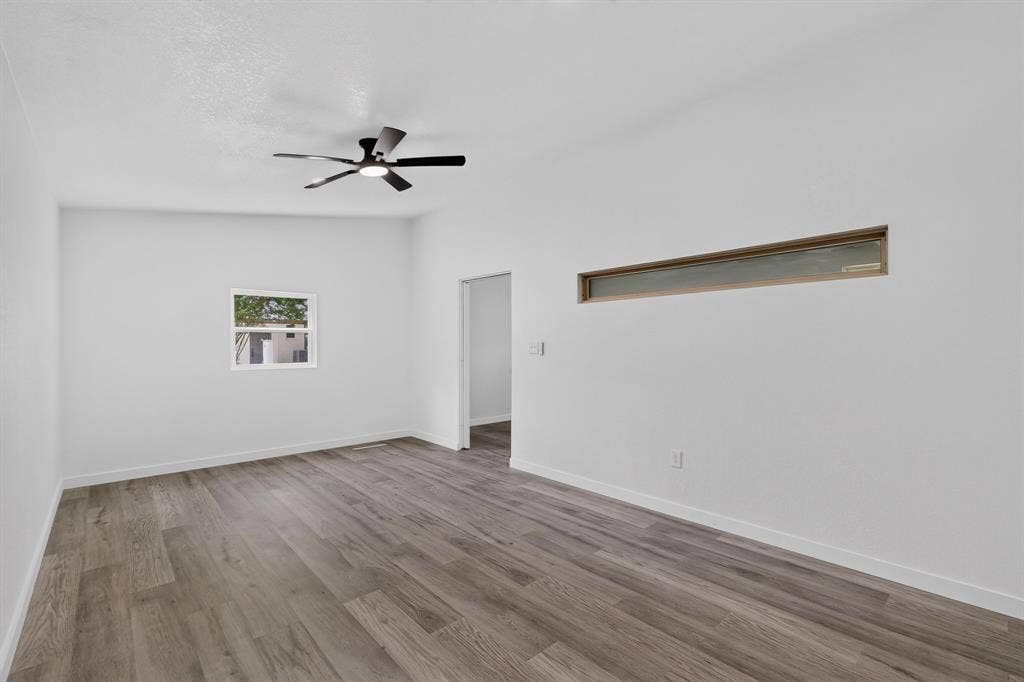 550 Glen Oaks Boulevard, Dallas, TX 75232 Room featuring wood-finish flooring, white walls, a multi-blade ceiling fan, a horizontal clerestory window, and a standard square window