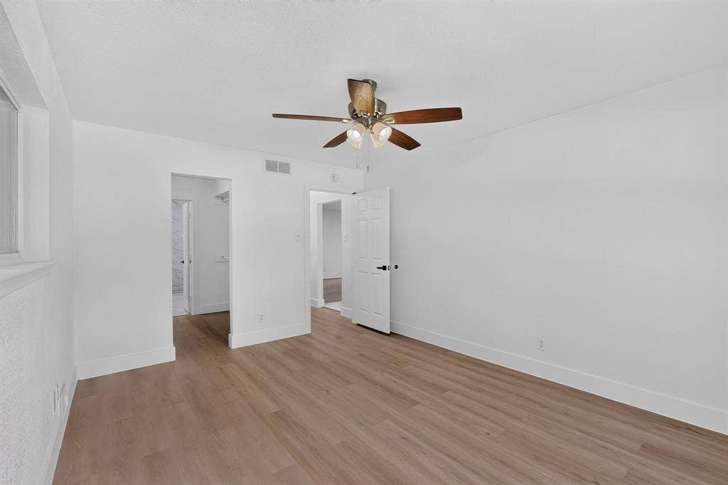 550 Glen Oaks Boulevard, Dallas, TX 75232 Room featuring wood-finish flooring, white walls, and a ceiling-mounted fan with integrated lighting