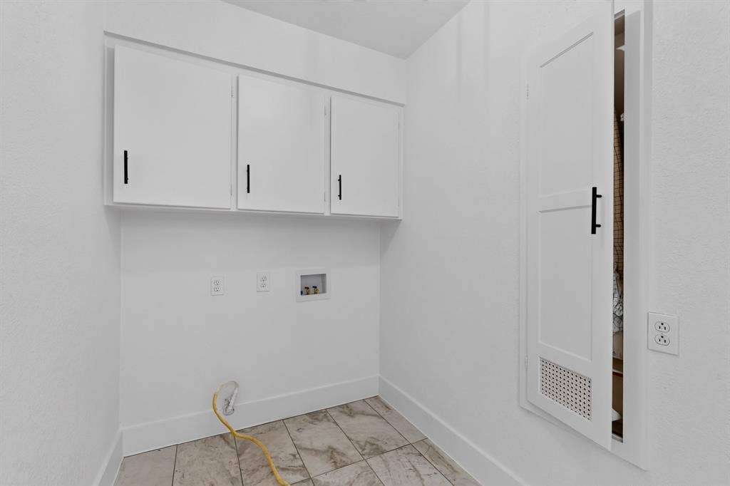 550 Glen Oaks Boulevard, Dallas, TX 75232 Utility room featuring white cabinetry, matte black hardware, tiled flooring, and a built-in louvered access door