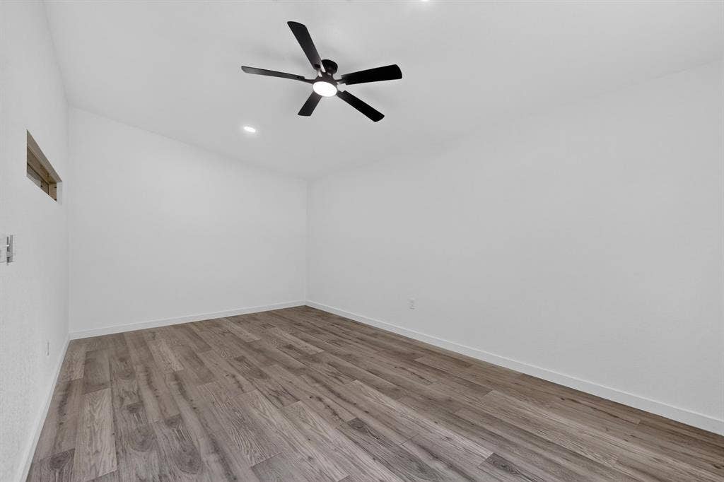 550 Glen Oaks Boulevard, Dallas, TX 75232 Interior space featuring wood-finish flooring, white walls, high ceiling, recessed lighting, and a matte black ceiling fan with integrated light