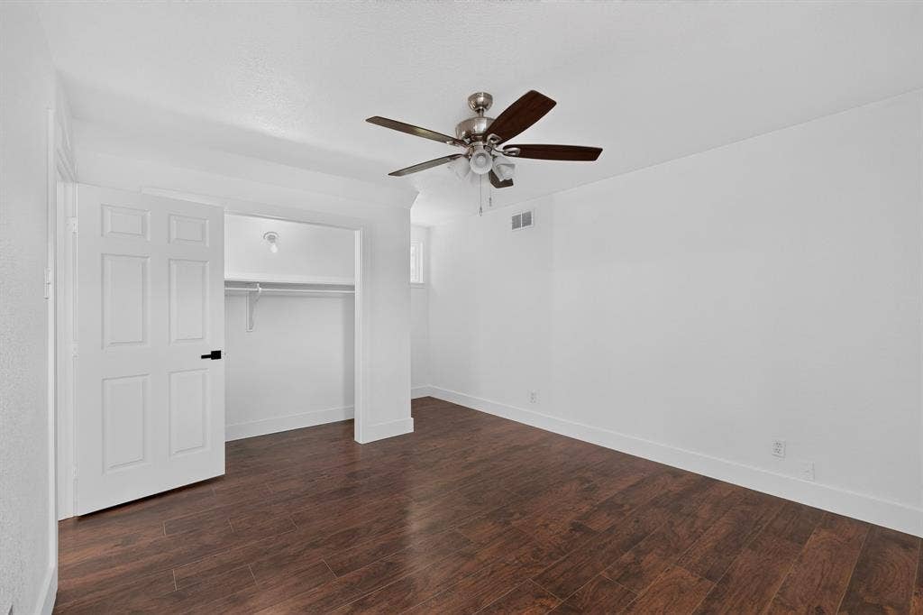 550 Glen Oaks Boulevard, Dallas, TX 75232 Interior space featuring wood-finish flooring, a five-blade ceiling fan with integrated lighting, and a closet with a built-in rod