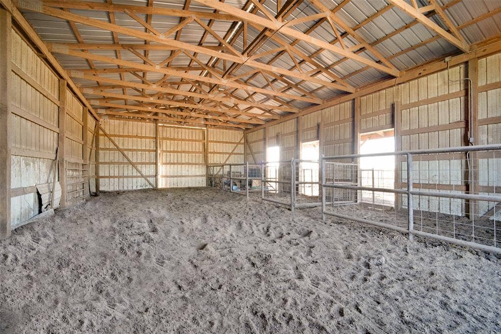 1957 E Fm 550, Rockwall, TX 75032 Open-span barn featuring exposed wood-truss ceiling, metal roofing, and built-in metal stall partitioning, and built in cattle cradle on the outside.