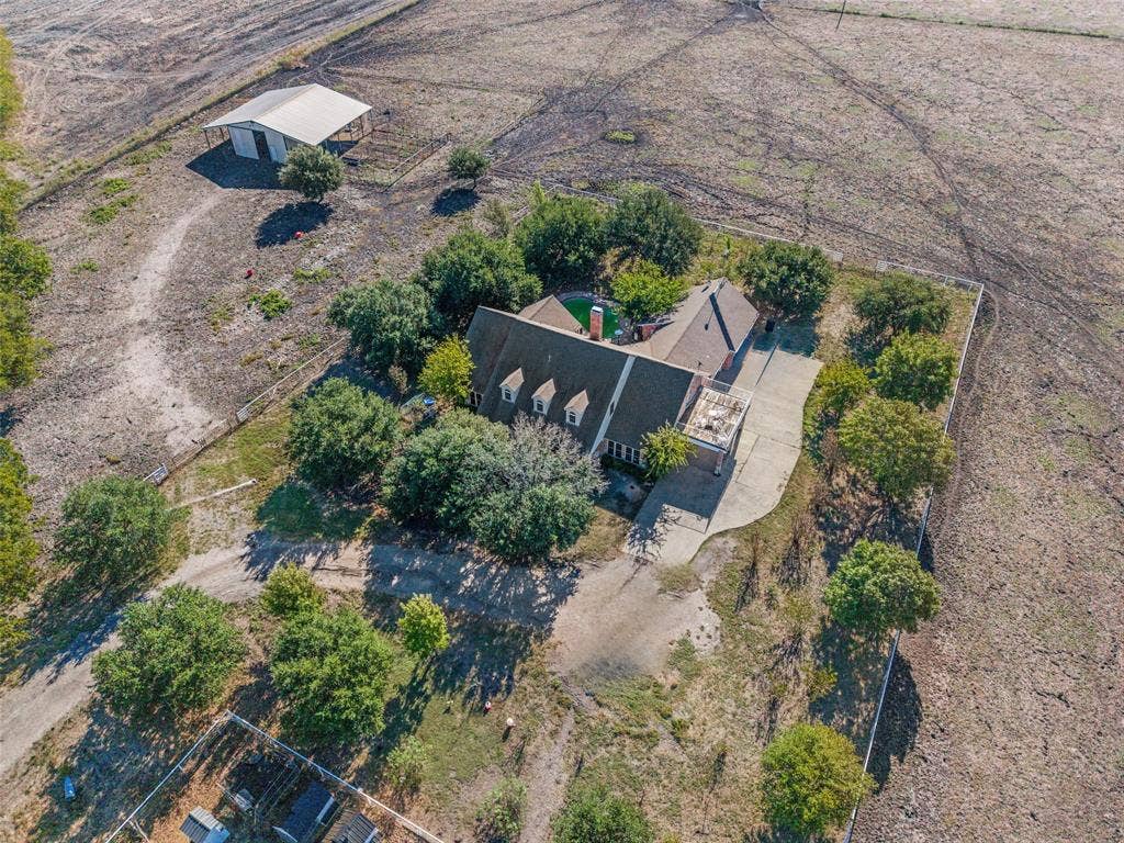 1957 E Fm 550, Rockwall, TX 75032 Expansive acreage featuring a multi-story residence, a detached metal barn, mature trees, and a concrete driveway