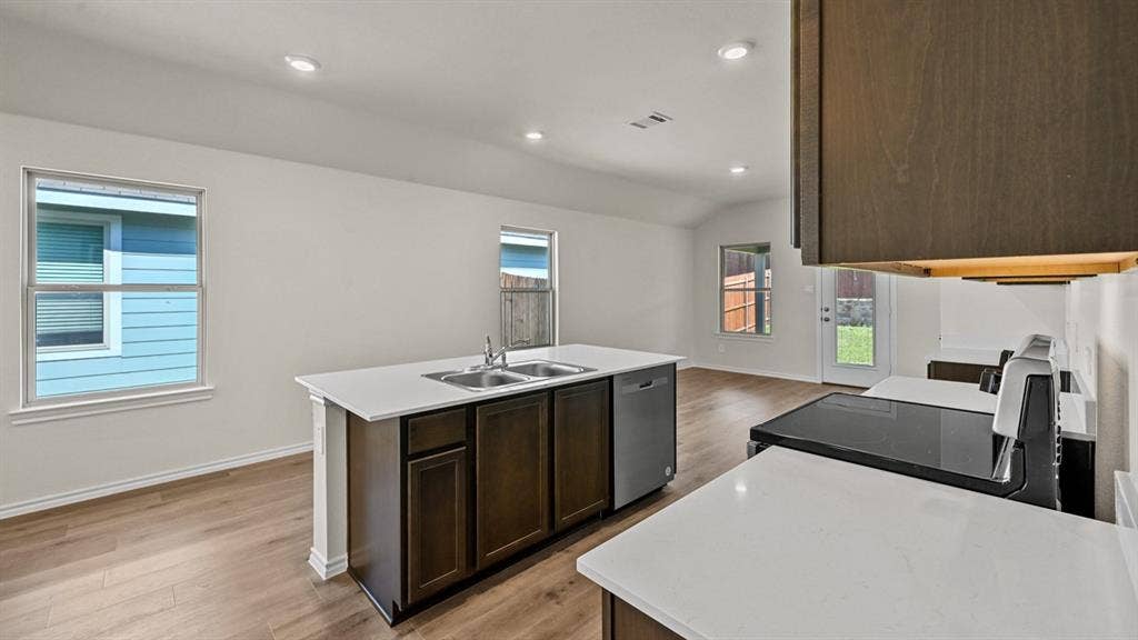 5743 Sunshine Lane, Crandall, TX 75114 Kitchen island with double basin sink, white countertops, wood-finish flooring, and recessed lighting