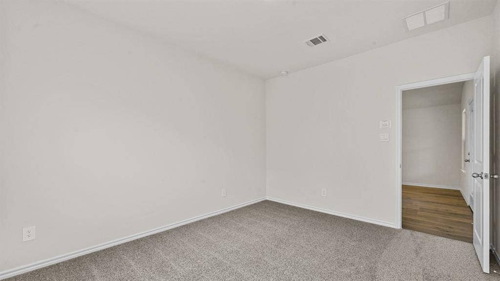 5743 Sunshine Lane, Crandall, TX 75114 Neutral paint palette, gray carpet, white trim, recessed lighting, wood-finish flooring visible through doorway