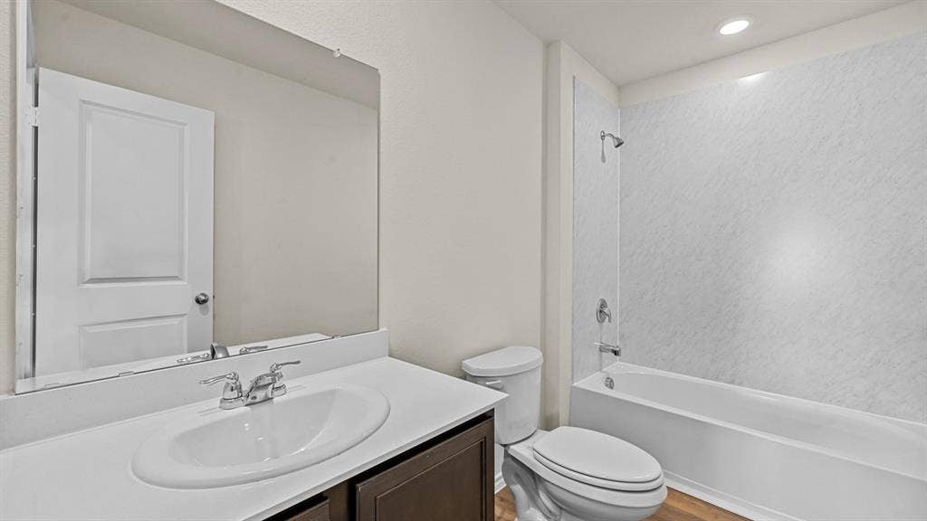 5743 Sunshine Lane, Crandall, TX 75114 Bathroom featuring a single vanity with an integrated sink, a large wall-mounted mirror, and a bathtub with a shower kit