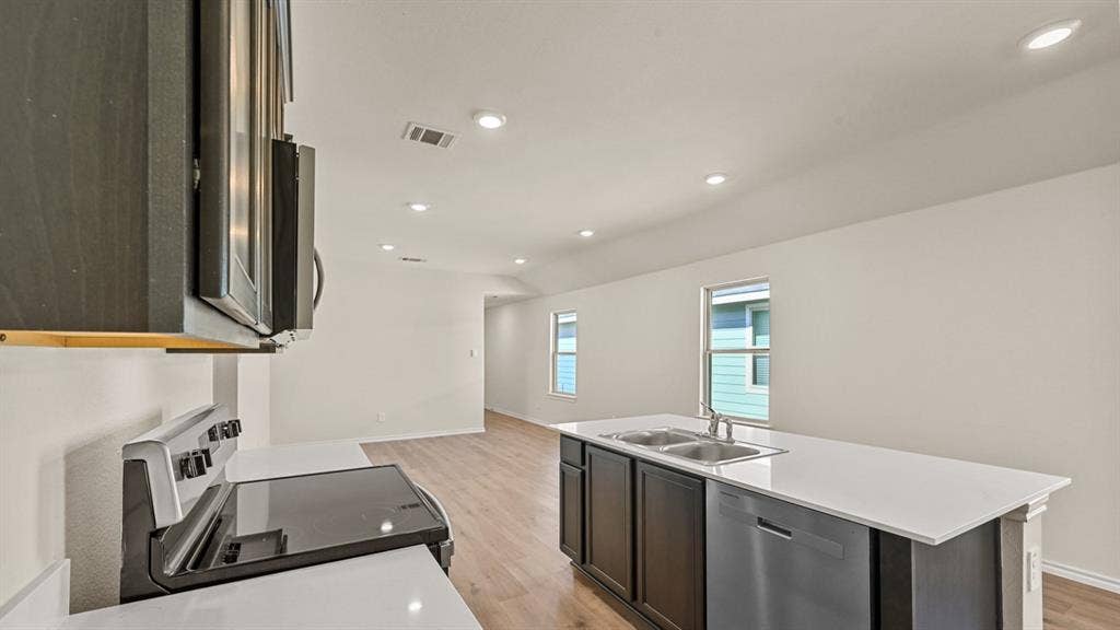 5743 Sunshine Lane, Crandall, TX 75114 Open concept kitchen featuring stainless steel appliances, recessed lighting, an island with a double basin sink, and wood-finish flooring