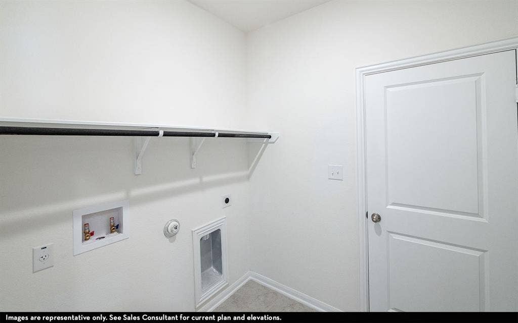 Dedicated utility space featuring a built-in overhead shelf and hanging rod, recessed water supply connection, recessed drain box, and a solid-core interior door
