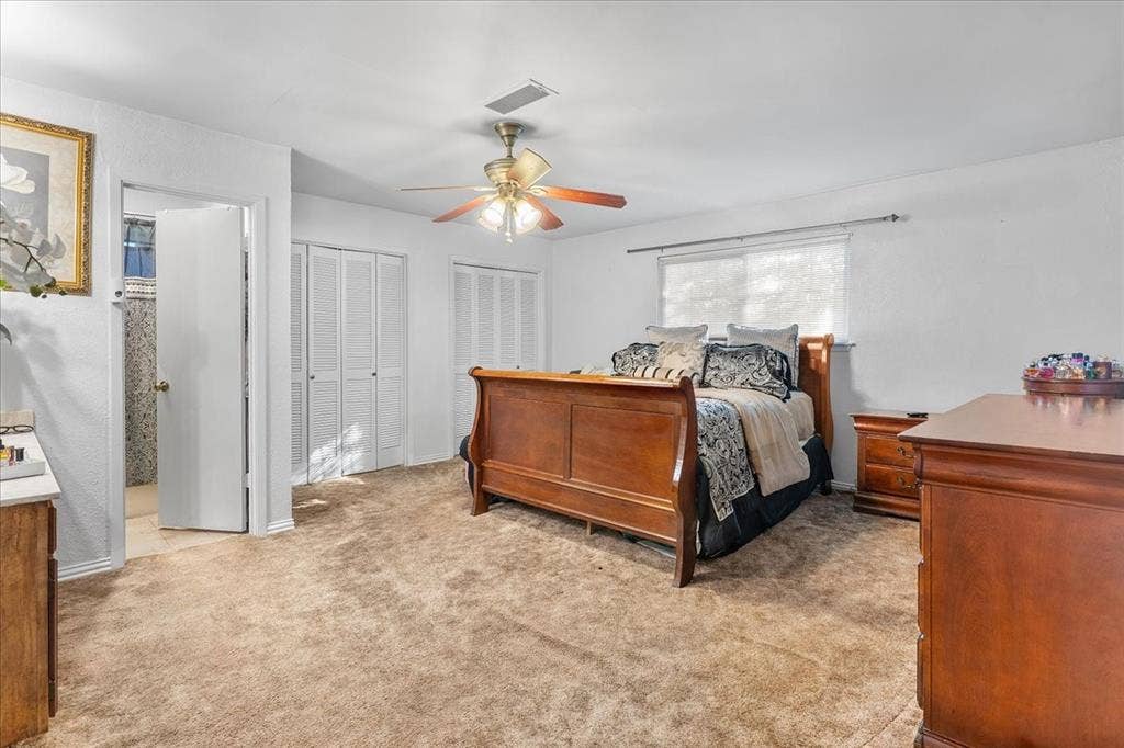 2702 Pebble Beach Drive, Lancaster, TX 75134 Room featuring carpeted flooring, a ceiling fan with integrated lighting, dual louvered closet doors, and a horizontal window