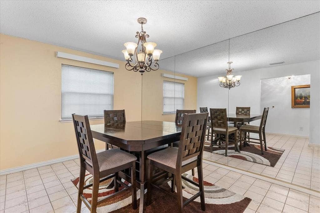 2702 Pebble Beach Drive, Lancaster, TX 75134 Tile flooring, decorative metal chandelier, and wall-to-wall mirrored paneling