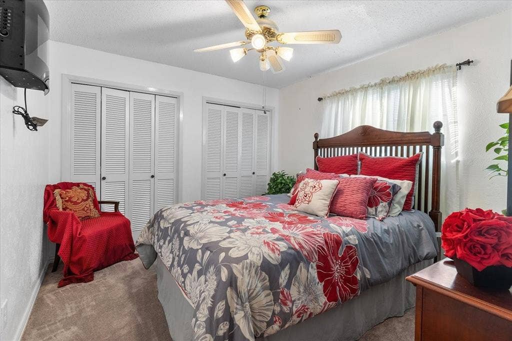 2702 Pebble Beach Drive, Lancaster, TX 75134 Interior space featuring neutral-toned carpeting, dual louvered-style closet doors, and a multi-light ceiling fan