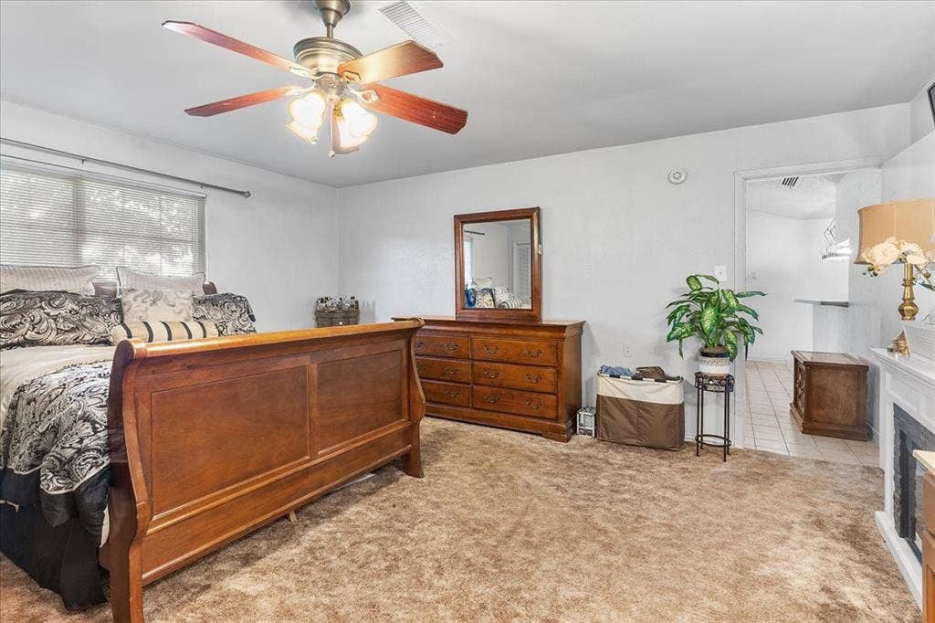 2702 Pebble Beach Drive, Lancaster, TX 75134 Spacious room featuring carpeting, a ceiling fan with integrated lighting, and a fireplace with a decorative mantel