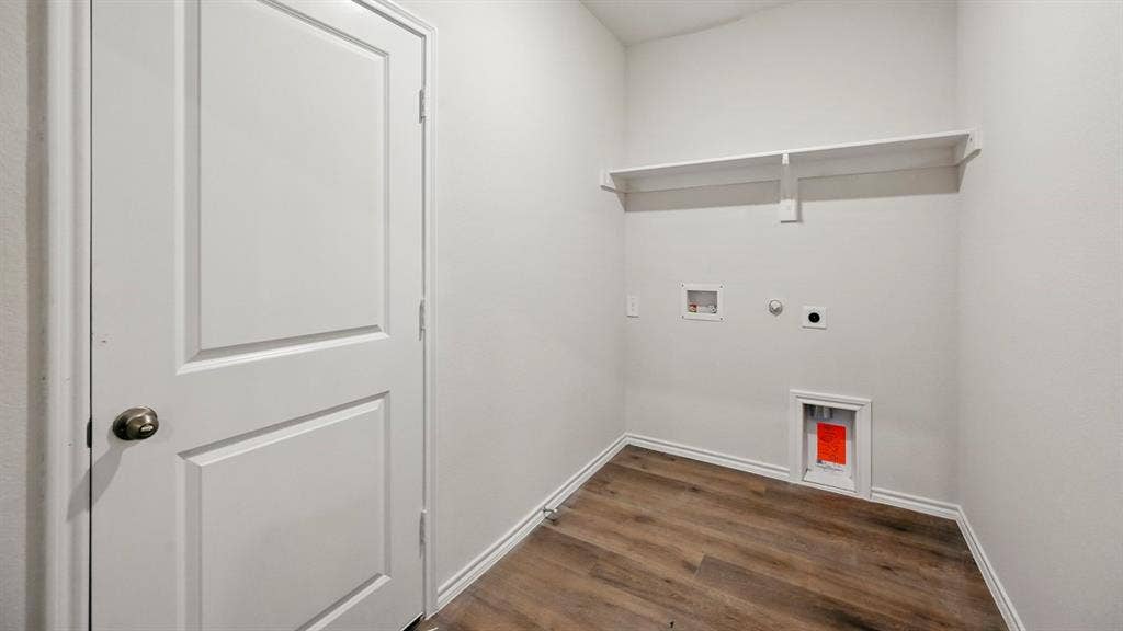 2620 Ocean View Grove, Crandall, TX 75114 Utility room featuring wood-finish flooring, white walls, and a built-in shelving unit