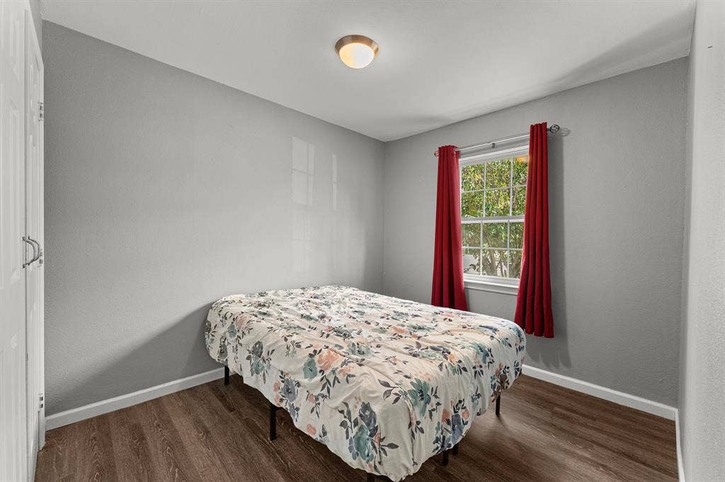 Neutral grey walls, wood-finish flooring, double-hung window, and flush-mount ceiling lighting