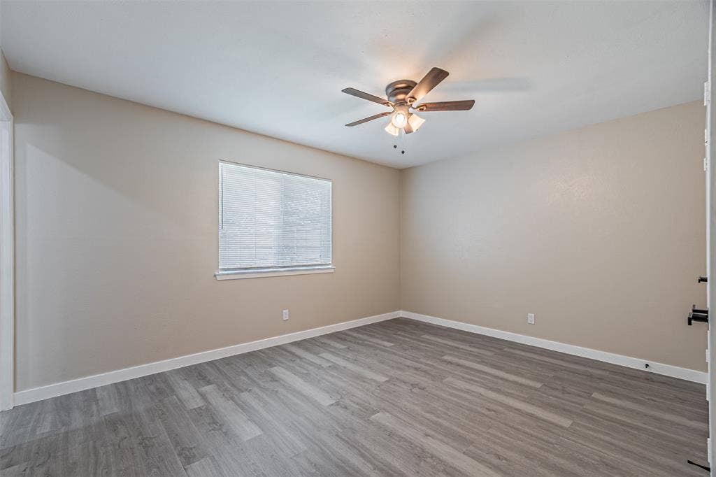 1509 Crockett Street, Garland, TX 75042 Neutral wall finishes, wood-finish flooring, and a central ceiling fan with integrated lighting