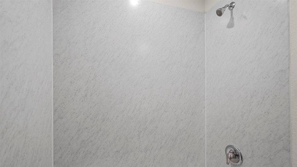 235 Whispering Pine Drive, Royse City, TX 75189 Shower enclosure featuring light-toned, veined wall panels and a polished chrome shower head and single-handle mixing valve