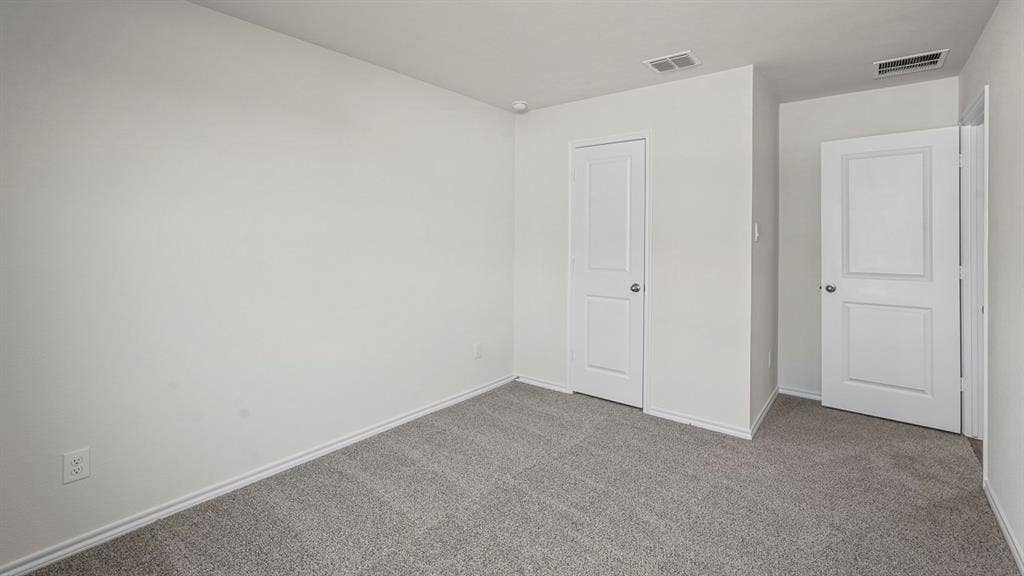 235 Whispering Pine Drive, Royse City, TX 75189 Neutral-toned carpeting, two-panel interior doors, and crisp white wall finish