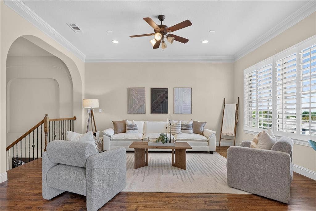 563 Rockingham Drive, Irving, TX 75063 Living area featuring wood-finish flooring, crown molding, arched architectural detail, recessed lighting, and interior plantation shutters