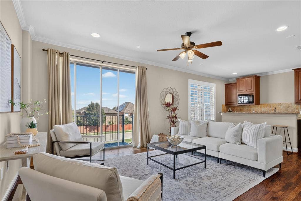 563 Rockingham Drive, Irving, TX 75063 Flex space featuring handscraped hardwood flooring, full bath, two large walk in closets, laundry room, and a large wet-bar with cabinets, mini sink and mini-fridge. Sliding glass door leads to balcony with winding staircase down to covered patio.
