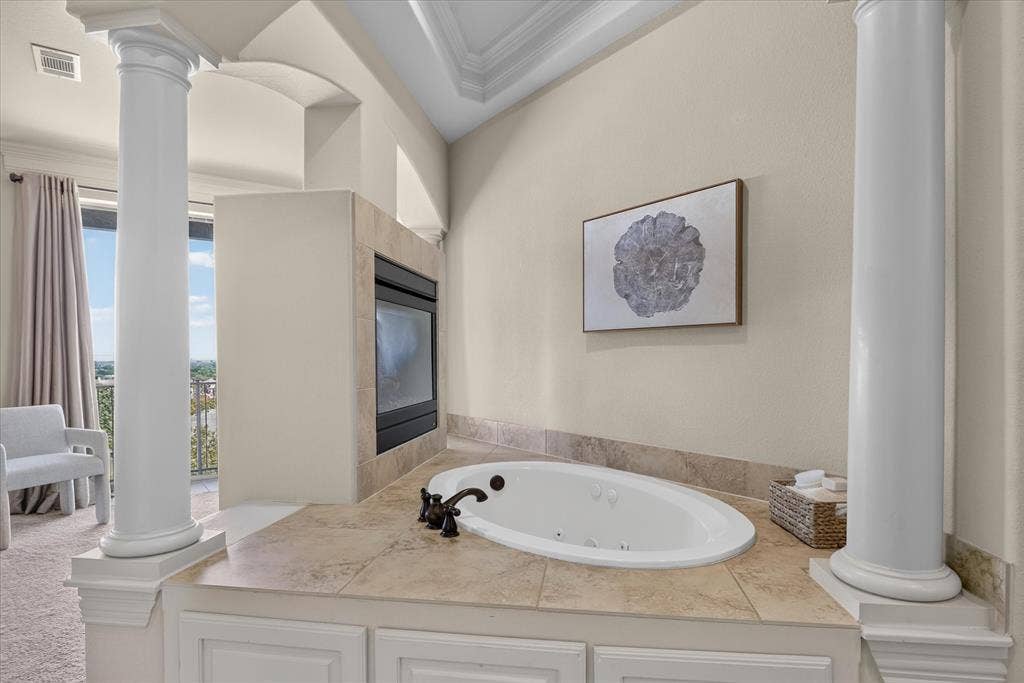563 Rockingham Drive, Irving, TX 75063 Jetted soaking tub with tile surround, dual classical-style columns, and built-in fireplace