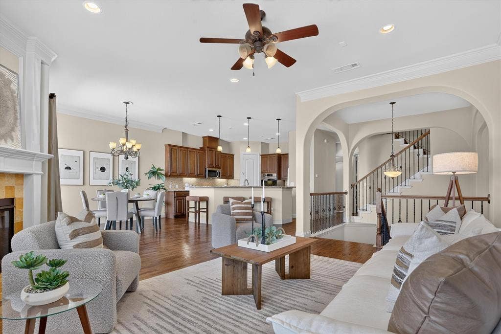 563 Rockingham Drive, Irving, TX 75063 Open-concept floor plan featuring wood-finish flooring, recessed lighting, crown molding, arched room entries, and a fireplace with a traditional mantel