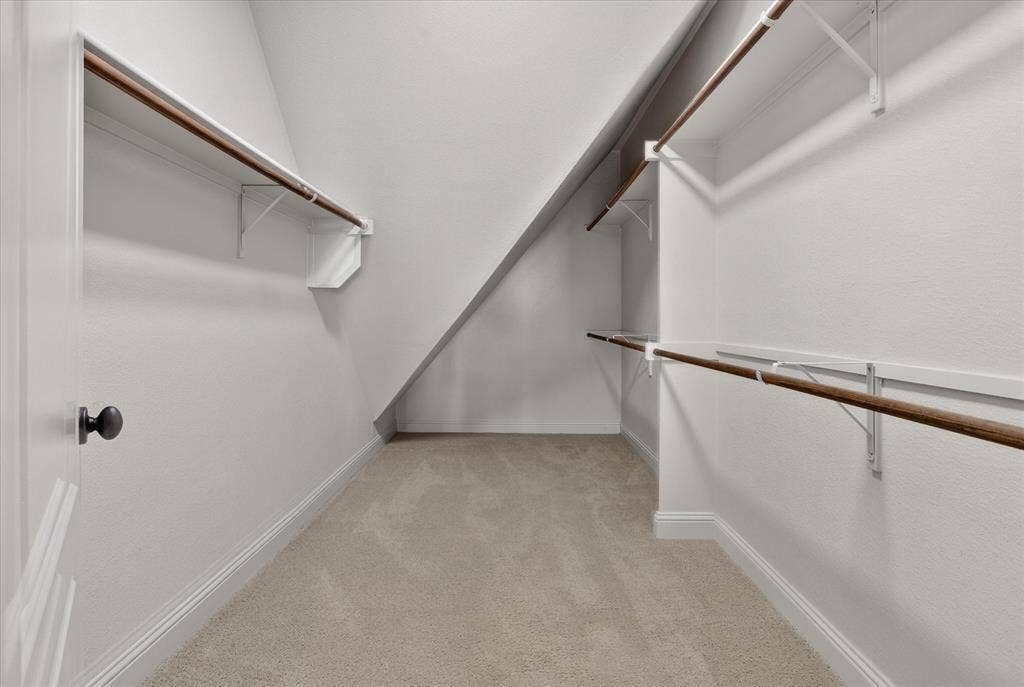 563 Rockingham Drive, Irving, TX 75063 Storage closet featuring neutral carpeting, multi-level shelving, and wood-finish clothing rods