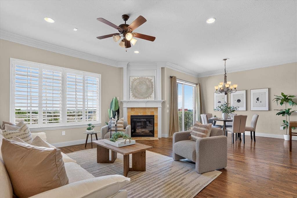 563 Rockingham Drive, Irving, TX 75063 Open-concept area featuring wood-finish flooring, a fireplace with a decorative mantel, plantation shutters, recessed lighting, and crown molding