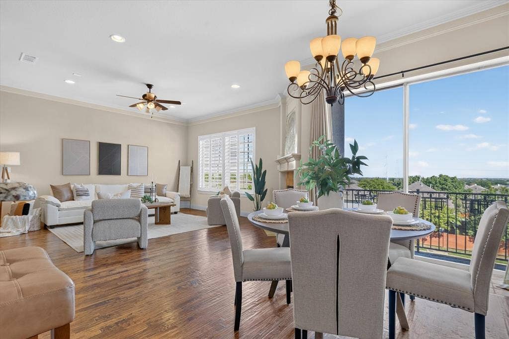 563 Rockingham Drive, Irving, TX 75063 Open-concept living and dining area featuring wood-finish flooring, recessed lighting, crown molding, a decorative chandelier, and floor-to-ceiling windows with a black metal balcony railing