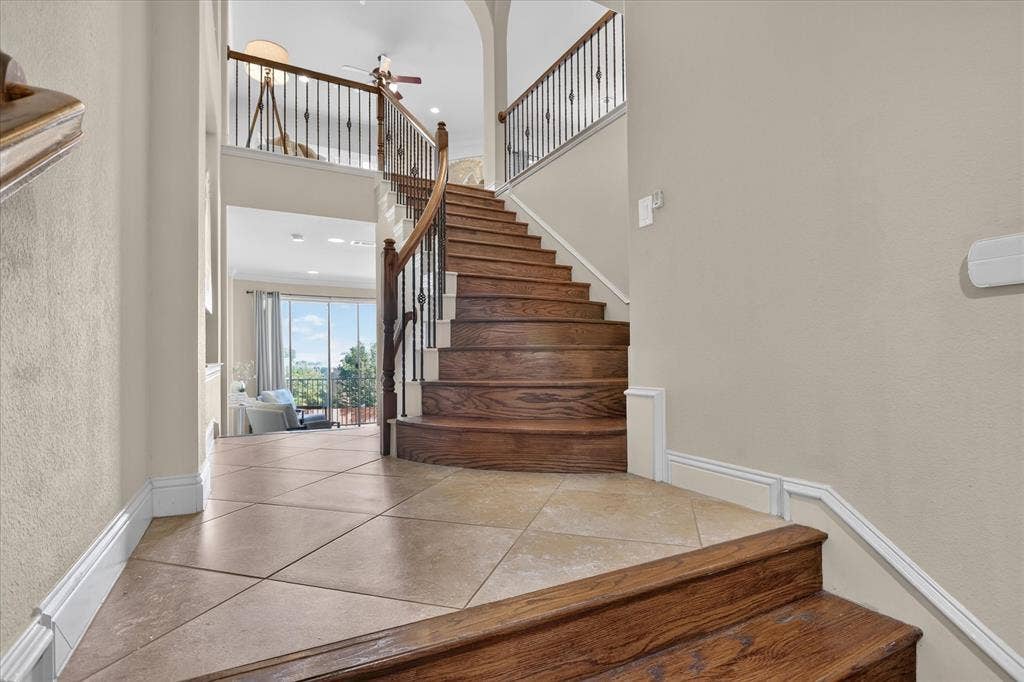 563 Rockingham Drive, Irving, TX 75063 Grand entryway featuring stone tile flooring, a curved staircase with stained wood treads, and metal balusters