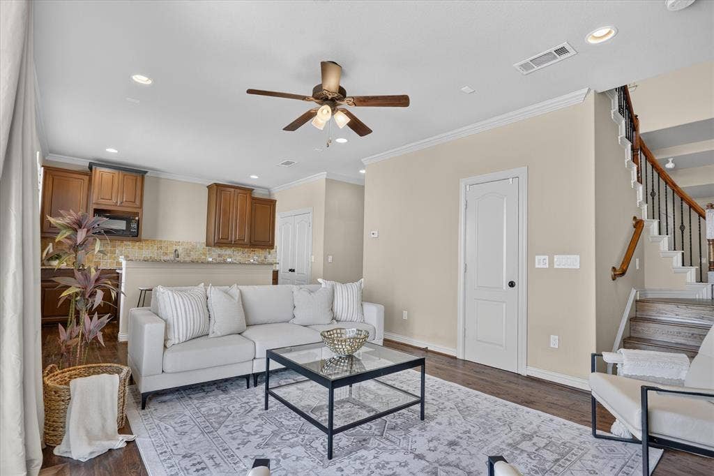 563 Rockingham Drive, Irving, TX 75063 Flex space featuring handscraped hardwood flooring, full bath, two large walk in closets, laundry room, and a large wet-bar with cabinets, mini sink and mini-fridge. Sliding glass door leads to balcony with winding staircase down to covered patio.